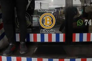 ARCHIVO - "Aceptamos Bitcoin" se anuncia en una barbería en Santa Tecla, El Salvador, el 4 de septiembre de 2021. El FMI instó al gobierno de El Salvador el martes 25 de enero de 2022 a eliminar el Bitcoin como moneda de curso legal. (AP Foto/Salvador Melendez, Archivo)