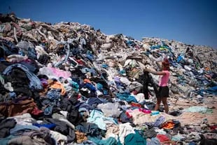 Una mujer busca ropa en buen estado en el vertedero de Alto Hospicio en Iquique, Chile, en desierto de Atacama