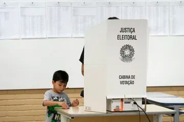 Un niño acompaña a un padre a votar durante las elecciones generales en Brasilia, Brasil, el domingo 2 de octubre de 2022