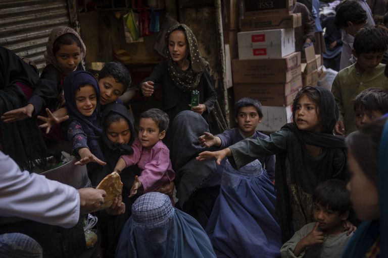 Mujeres y niños afganos reciben donaciones de pan en la Ciudad Vieja de Kabul, Afganistán