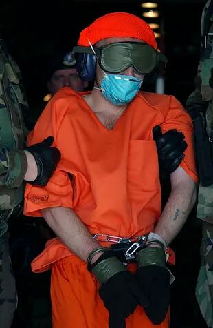 En una imagen proporcionada por la Fuerza Aérea, David Hicks, un australiano que fue capturado luchando para los talibanes, es conducido desde un avión de carga en el primer día de operaciones de la prisión en la Bahía de Guantánamo en Cuba, el 11 de enero de 2002.
