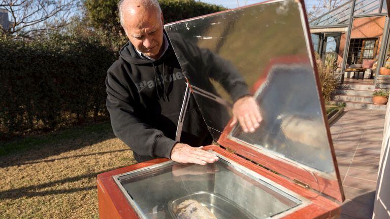 Alfredo Esteves cocina un carré de cerdo en un horno solar