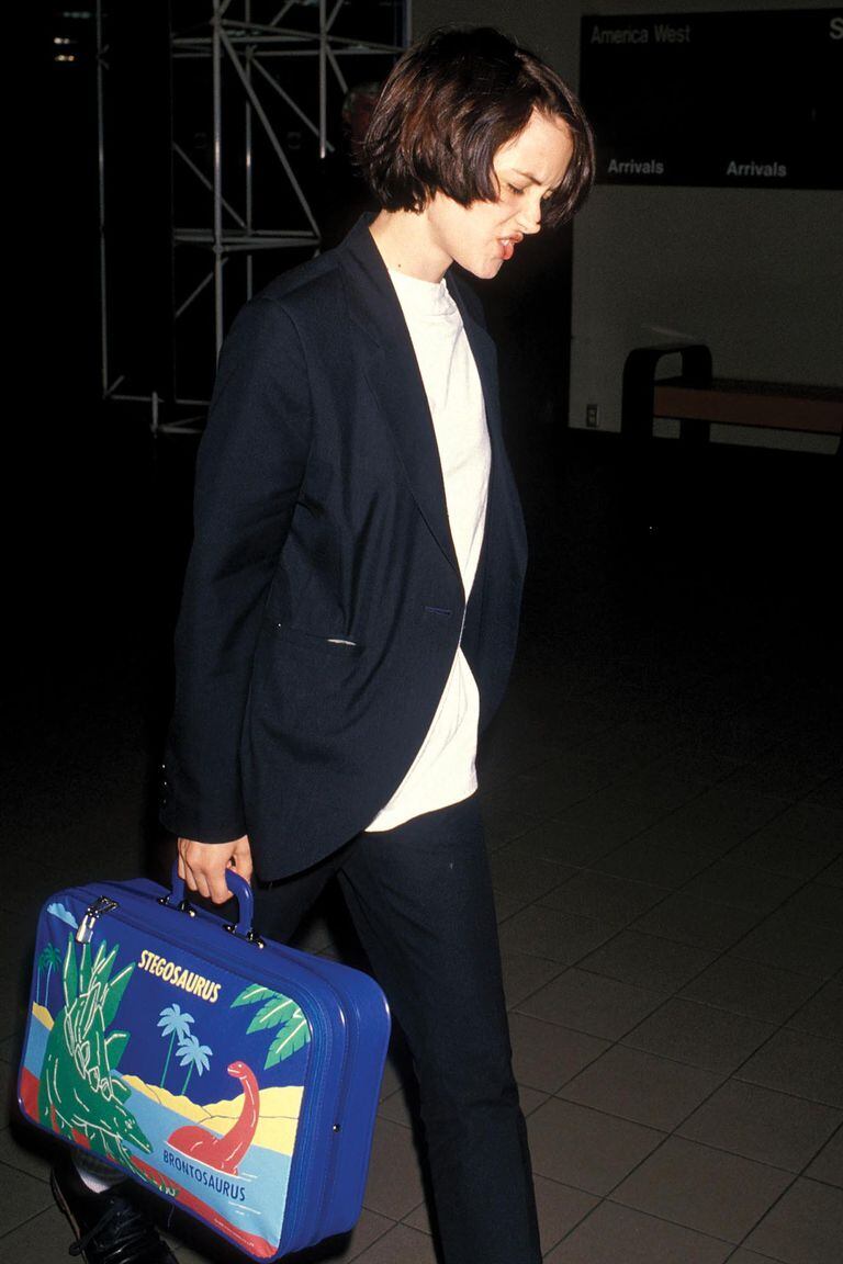 Llega al aeropuerto de Los Ángeles vestida con un traje de líneas masculinas y una camiseta que le queda grande, el estilismo que impuso en los 90. 