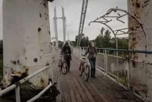 Residentes cruzan un puente atacado en la ciudad de Izium el 14 de septiembre. (Nicole Tung/The New York Times)