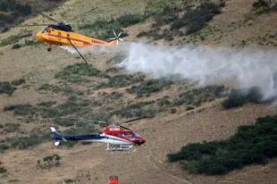 Dos helicópteros combaten un incendio en Springville, Utah (Kristin Murphy/The Deseret News vía AP)