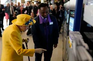 La reina Isabel prueba una Oyster Card en las máquinas de Paddington Station. (Photo by Andrew Matthews / POOL / AFP)