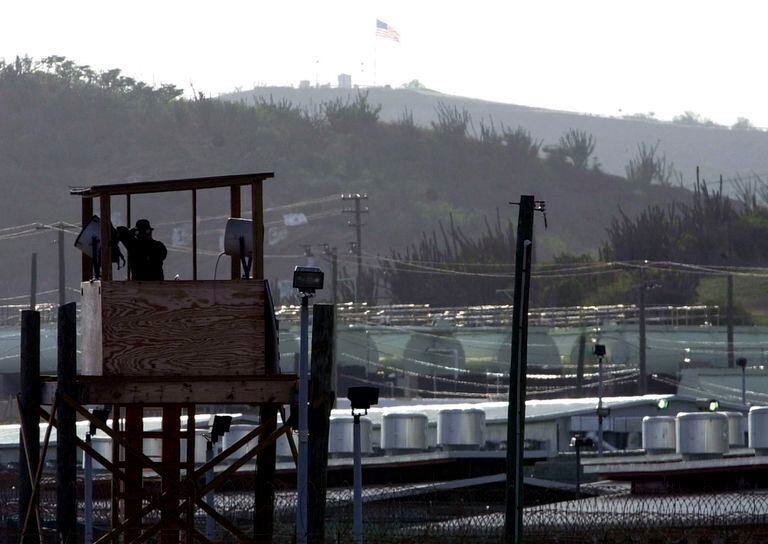 ARCHIVO - En imagen de archivo del 10 de septiembre de 2002, un oficial de la policía militar del Ejército de Estados Unidos observa con binoculares desde una torre de vigilancia en el Campamento Delta en la Base Naval de Estados Unidos en la Bahía de Guantánamo, Cuba. (AP Foto/Lynne Sladky, archivo)