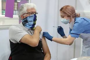 La trabajadora de la salud Nicole Clark administra una vacuna contra la Covid-19 al residente de Glasgow John Loch en el NHS Louisa Jordan Hospital en Glasgow el 10 de febrero de 2021