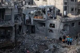 Rescatistas palestinos buscan víctimas entre los escombros de los edificios bombardeados