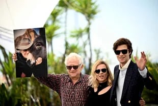 the Polish director Jerzy Skolimowski brandishes the photo of a donkey, the protagonist of his film in competition at Cannes;  with director, producer and screenwriter Ewa Piaskowska and actor Lorenzo Zurzolo  