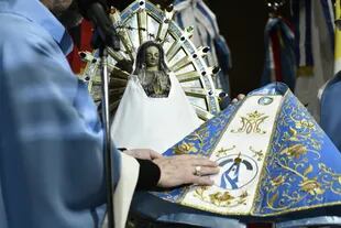 Las manos de la Virgen se encontraban juntas sobre su pecho y sostenían un manto azul cubierto de estrellas