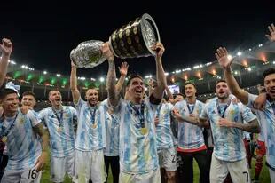 Argentina's Lionel Messi holds the trophy as he celebrates with teammates after winning the Conmebol 2021 Copa America football tournament final match against Brazil at Maracana Stadium in Rio de Janeiro, Brazil, on July 10, 2021. - Argentina won 1-0. (Photo by CARL DE SOUZA / AFP)