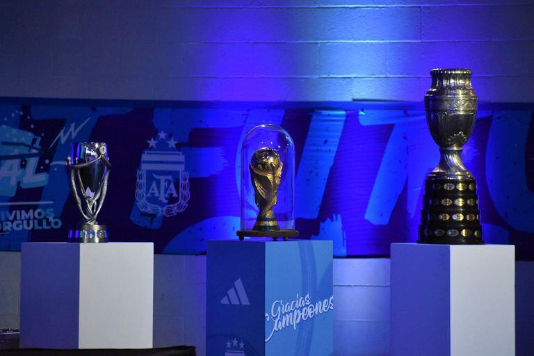 Los tres trofeos logrados por el seleccionado mayor en 2021 y 2022: el de la Finalissima, la Copa del Mundo y la Copa América, exhibidos durante la asamblea anual de AFA, en Ezeiza.