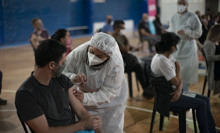 La supervisora de enfermerÕa Paola Almiron inocula a un hombre con una dosis de la vacuna de Sinopharm contra el COVID-19 en un gimnasio en las afueras de Buenos Aires, el viernes 9 de julio de 2021. (AP Foto/Victor R. Caivano)