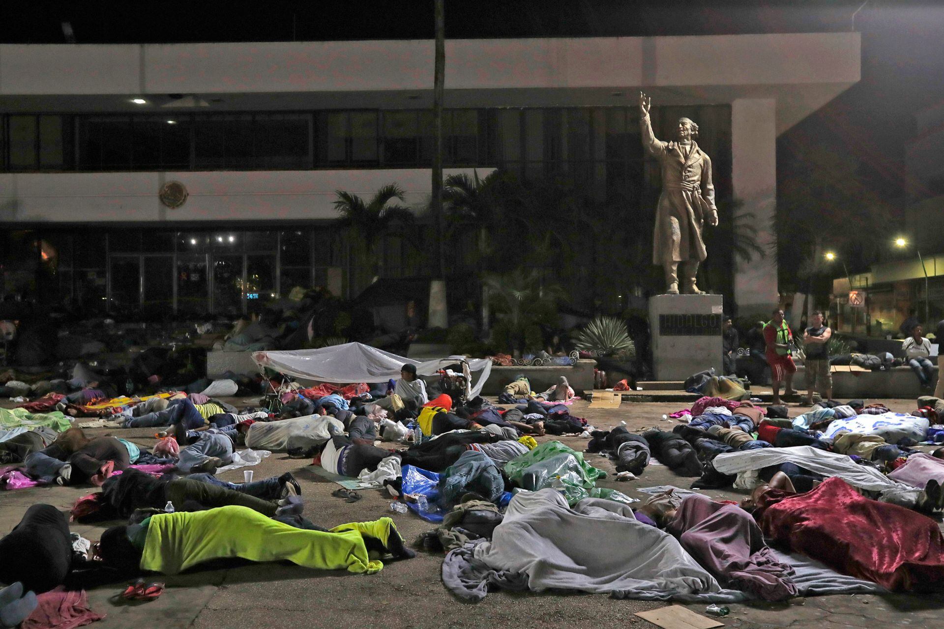 Los migrantes hondureños duermen en la ciudad de Tapachula, en una plaza pública con una estatua del héroe nacional mexicano Miguel Hidalgo, un sacerdote que lanzó la Guerra de Independencia de México en 1810