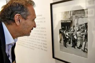 El galerista Daniel Maman observa una foto de Alberto Greco y Rómulo Macció, retratados por Sameer Makarius en 1961
