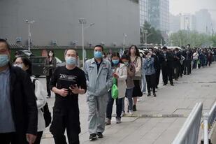 La gente espera en la cola para hacerse la prueba del coronavirus en un lugar de recogida de hisopos en Pekín el 25 de abril de 2022.