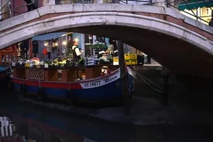 Esta fotografía tomada el 20 de febrero de 2023 muestra una góndola amarrada en el Canal Grande de Venecia, durante una fuerte marea baja en la ciudad lagunar de Venecia