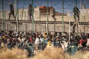 En esta imagen de archivo, agentes antimotines acordonan la zona tras la llegada de migrantes a suelo español luego de cruzar las vallas fronterizas que separan el enclave de Melilla de Marruecos, en Melilla, el 24 de junio de 2022
