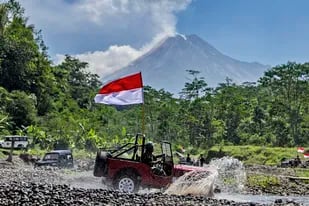 ARCHIVO - Un auto con la bandera de Indonesia recorre una senda cerca del monte Merapi, Indonesia, durante el Día de la Independencia, 17 de agosto de 2021 en Sleman, Indonesia.(AP Foto/Slamet Riyadi, File)