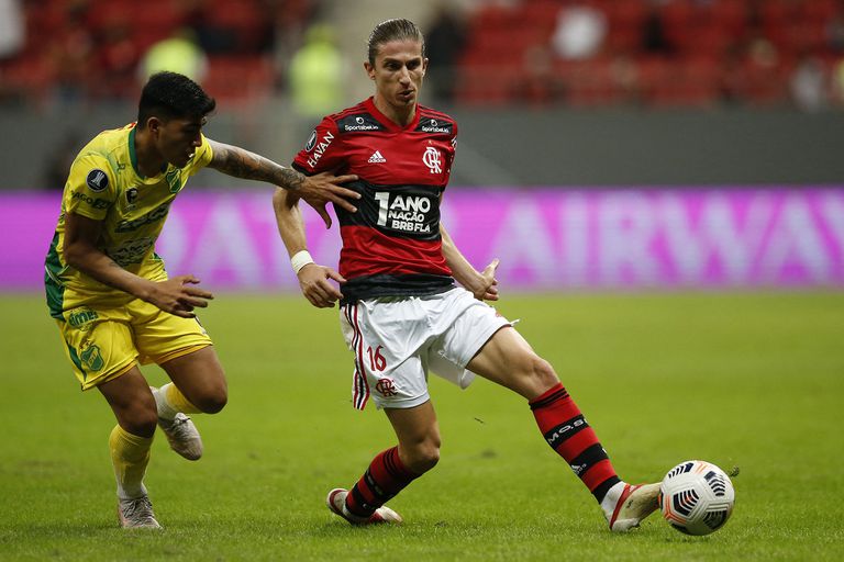 Filipe Luis mide el pase ante la marca de Lautaro Escalante; en Brasilia y ante 18 mil espectadores, Flamengo demostró contundencia para vapulear en el resultado a Defensa y Justicia