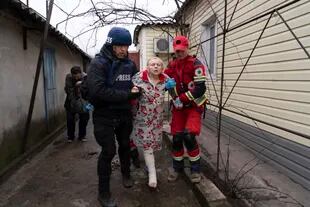 El fotógrafo de Associated Press Evgeniy Maloletka ayuda a un paramédico a transportar a una mujer herida durante un bombardeo en Mariupol, este de Ucrania, el miércoles 2 de marzo de 2022. 
