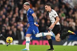 Enzo Fernández (L) lleva la pelota seguido de cerca por Joao Palhinha en el partido entre Chelsea y Fulham por la Premier League.