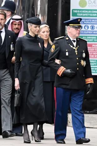 Tomados del brazo, el príncipe Alberto y la princesa Charlene de Mónaco (con vestido-abrigo de Terence Bray, tocado de red, zapatos Dior y cartera Prada) no pueden ocultar su emoción.