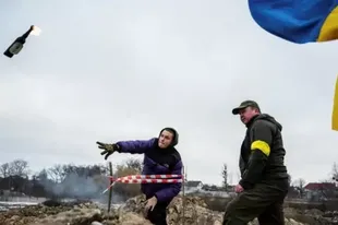 Civiles entrenan en Ucrania cómo lanzar cócteles molotov ante la invasión rusa.