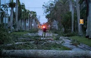 A man walks through debris on a street after Hurricane Ian in Punta Gorda, Florida on September 29, 2022.