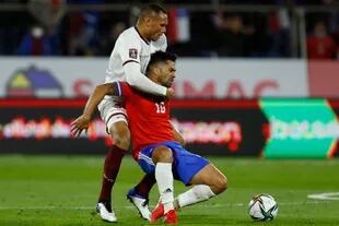 Luis Jiménez y  Adrián Martinez luchan por la pelota durante el partido de eliminatorias de la Copa del Mundo Qatar 2022 que disputan Chile y Venezuela
