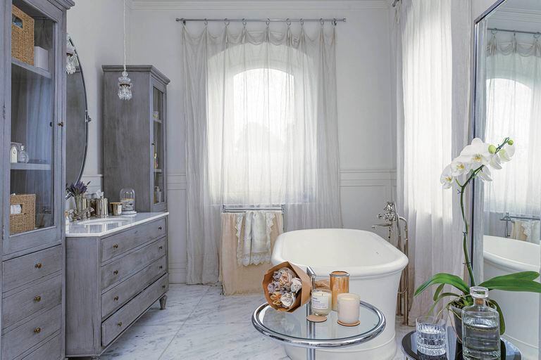 Foto de un baño con pisos de mármol y bañadera exenta.