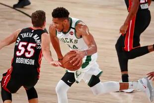 6 de septiembre de 2020; Lake Buena Vista, Florida, Estados Unidos; El alero de los Milwaukee Bucks, Giannis Antetokounmpo (34), regatea al escolta del Miami Heat, Duncan Robinson (55), durante la primera mitad del cuarto juego de la segunda ronda de los Playoffs de la NBA 2020 en ESPN Wide World of