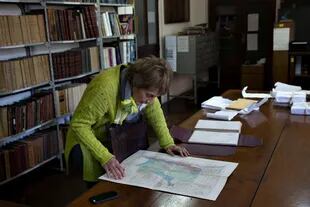 Graciela Swiderski, la jefa del Departamento de Escritos y Biblioteca del Archivo General de la Nación, revisa uno de los mapas