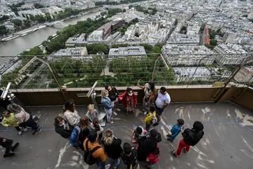 Visitantes en el primer piso de la Torre Eiffel, detrás la hermosa vista de París