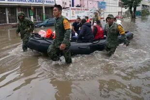 Soldados trasladan a unos trabajadores de salud en un bote inflable en una calle inundada de Tula, en el estado de Hidalgo, México, en septiembre de 2021