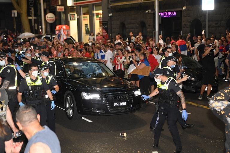 La policía arroja gas pimienta para despejar el camino del automóvil que traslada a Novak Djokovic en Melbourne el 9 de enero de 2022.