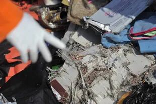 Un rescatista muestra restos del avión Boeing