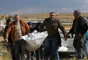 Sirios llevan el cuerpo de heridos por el terremoto. (Photo by Louai Beshara / AFP)