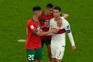 Los jugadores marroquíes Achraf Dari y Jawad El Yamiq tratando de consolar a Cristiano Ronaldo 
