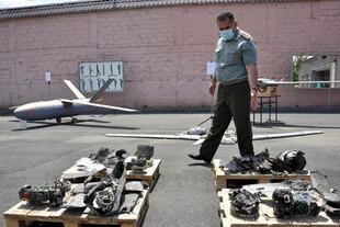 Un funcionario armenio mostrando lo que supuestamente son drones derribados durante los enfrentamientos con las fuerzas de Azerbaiyán el año pasado