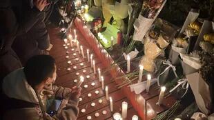 Manifestantes se reúnen a lo largo de una calle con velas y ramos de flores durante una concentración en favor de las víctimas de un incendio mortal, así como una protesta contra las duras restricciones Covid-19 de China, en Pekín, el 28 de noviembre de 2022