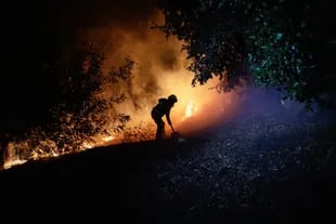 Un bombero trabaja, mientras un incendio forestal quema partes de áreas rurales en Quillón, Chile, 2 de febrero de 2023