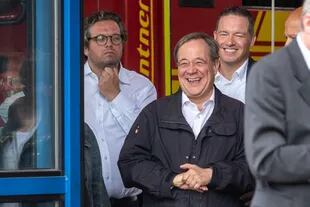 El primer ministro del estado de Renania del Norte-Westfalia, líder de la Unión Demócrata Cristiana (CDU) y candidato de la CDU a la Cancillería Armin Laschet (centro) rie mientras el presidente alemán pronuncia un discurso después de que visitaron el centro de control de incendios y rescate de Rhein-Erft y en Erftstadt, en el oeste de Alemania