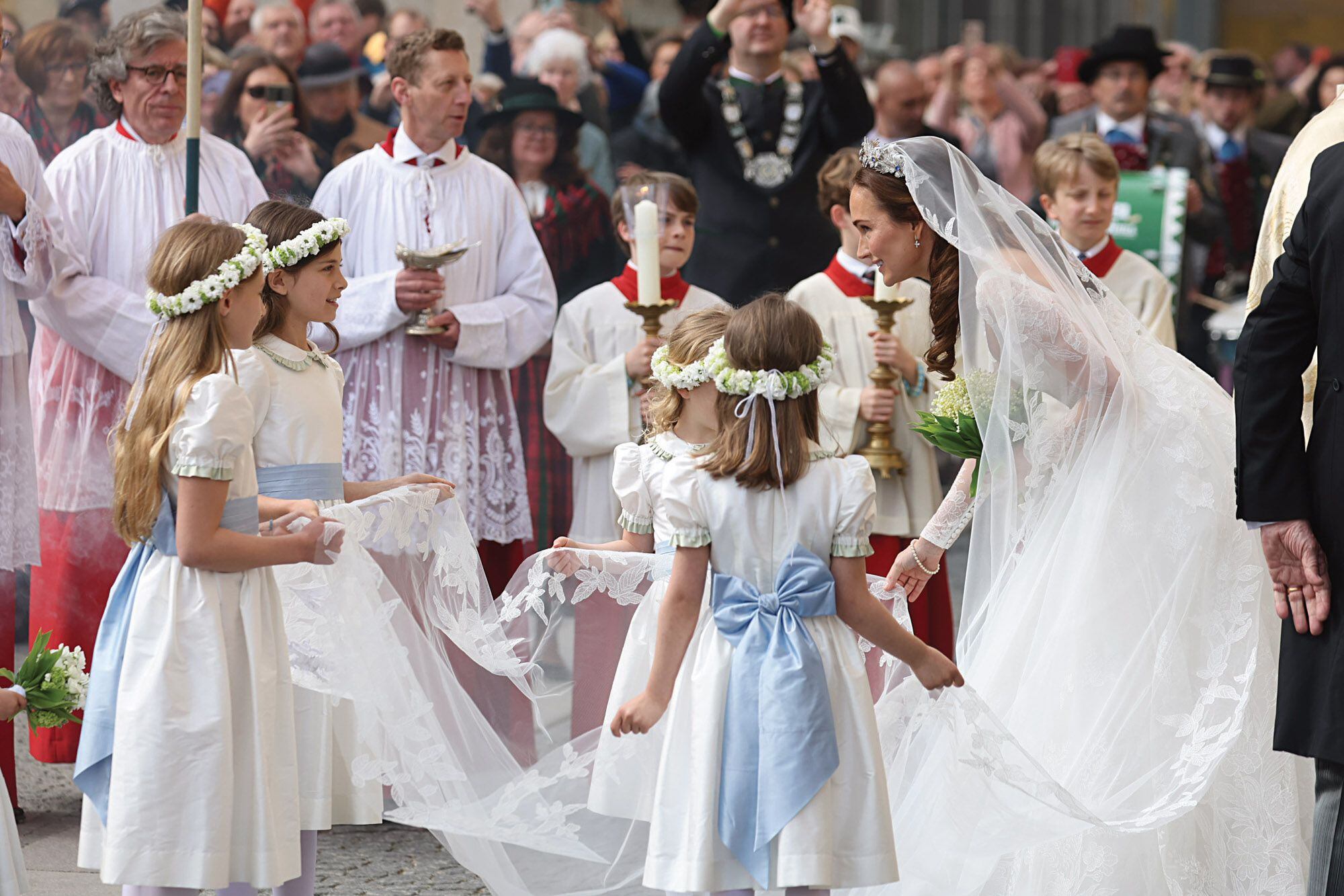 Sophie-Alexandra Evekink, conversando las damitas de honor, vestidas en blanco con fajas celestes de seda. La diseñadora bávara Gabi Nitzl tuvo a su cargo el outfit de los niños, así como también de sus arreglos florales. 