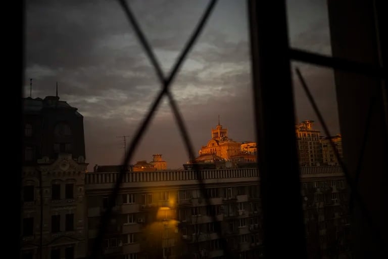 Vista de la puesta de sol a través de las ventanas que han sido selladas para evitar el estallido de los cristales por posibles ondas de choque en el centro de Kiev, Ucrania, el lunes 28 de febrero de 2022.