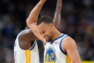 El jugador de los Warriors de Golden State Stephen Curry, felicita a su compañero Draymond Green en los últimos instantes del tercer juego de la serie de primera ronda del playoff de la NBA frente a los Denver Nuggets