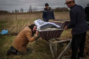 En esta imagen de archivo, Nadiya Trubchaninova, llora sobre el féretro de su hijo Vadym, quien fue asesinado el 20 de marzo por soldados rusos en Bucha, Ucrania, durante su entierro en un cementerio próximo a Mykulychi, a las afueras de Kiev, el 16 de abril de 2022. (AP Photo/Rodrigo Abd, archivo)