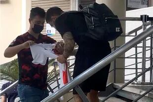 Elías Gómez firmando camisetas en la puerta de la clínica, antes de someterse a los estudios médicos