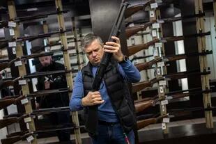 Un cliente revisa su rifle en una tienda de armas en Lviv, en el oeste de Ucrania. El Ejército ruso está haciendo frente a toda una nación en armas, civiles y militares 